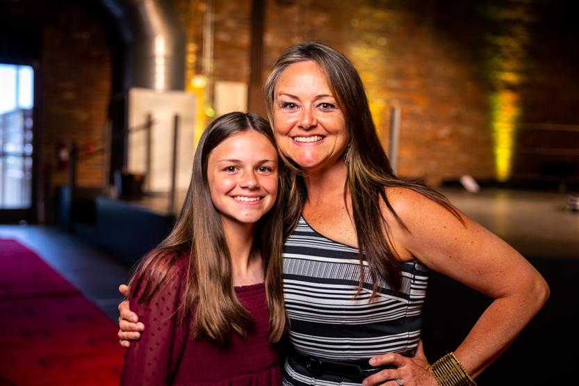 Two women smile while hugging